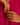 Close-up of a hand wearing a gold sculptural ring against a pink fabric background