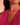 Gold necklace with a sculptural pendant worn by a person in a pink top.