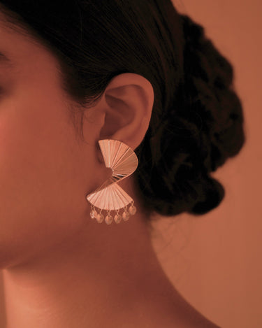 Close-up of an ear wearing a silver jhumka earring with a blurred background